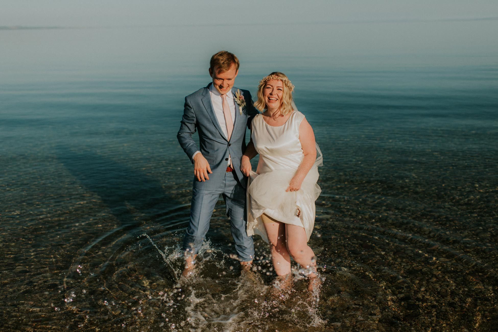 bride and groom splashing in the sea