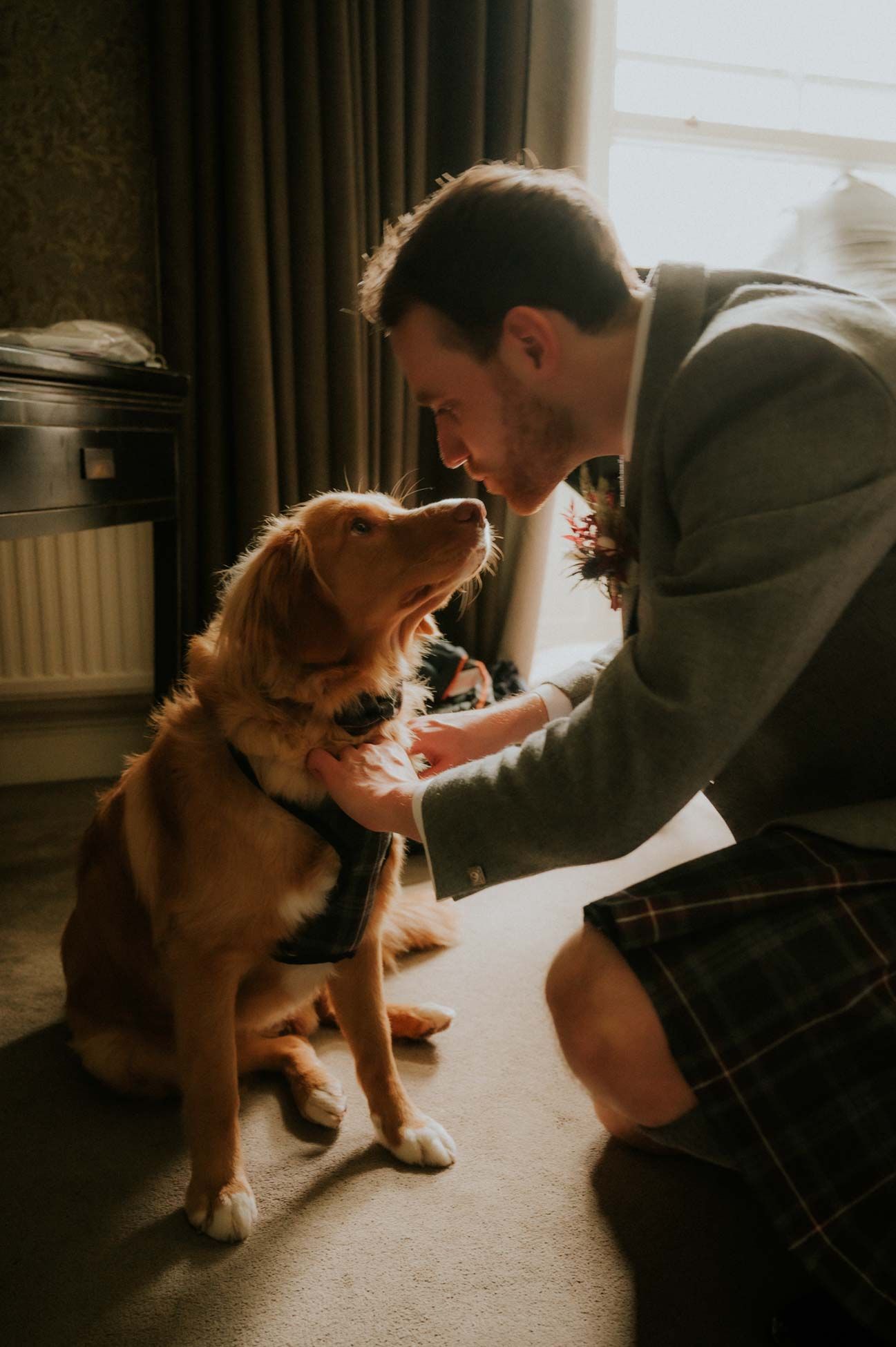 Groom placing a bow tie on dog 