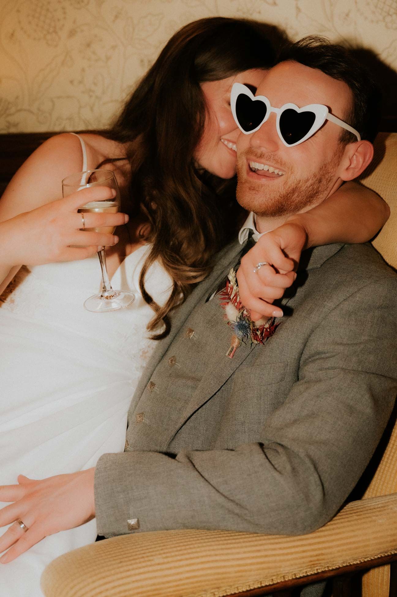 bride and groom cuddling with white sunglasses 